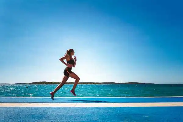 Woman running showing strong leg muscle Carlton